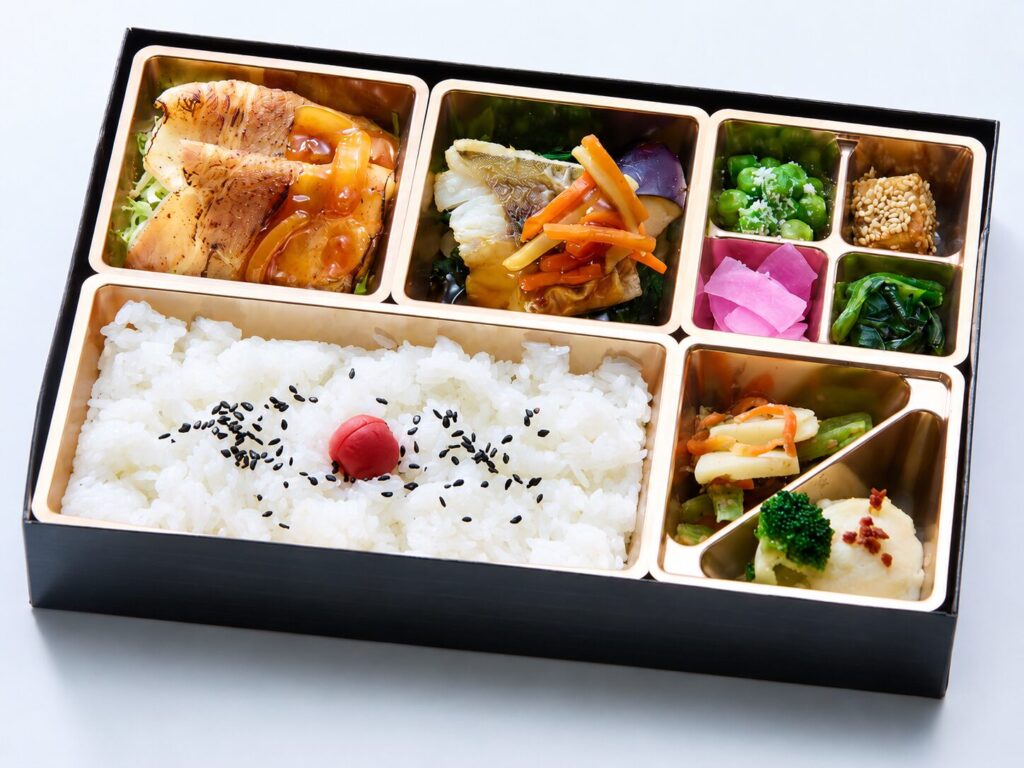 生姜焼きと白身魚の和風あんかけ、温野菜と副菜を盛り付けた弁当