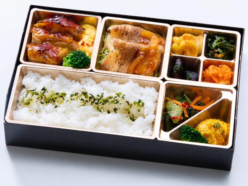 照り焼きチキンステーキと生姜焼き、副菜を盛り付けた弁当