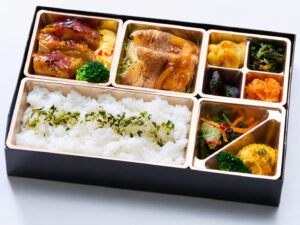 照り焼きチキンステーキと生姜焼き、副菜を盛り付けた弁当